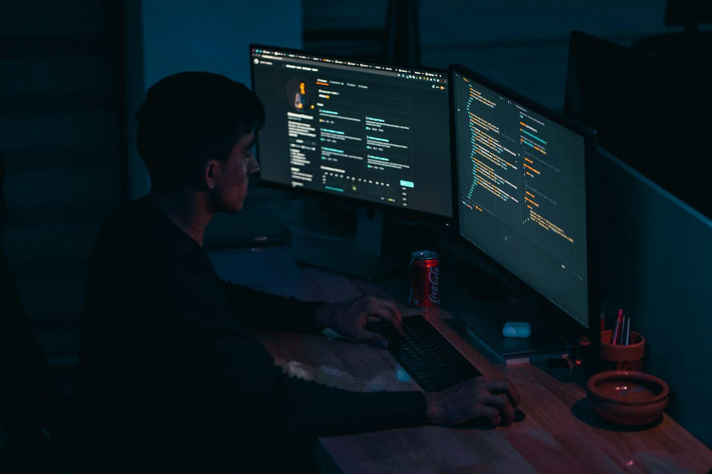 Développeur travaillant de nuit sur deux écrans de code